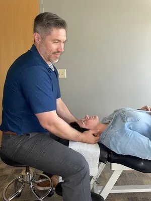 Chiropractor St Louis Park MN Travis Gilbertson Adjusting Patients Neck